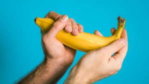 Symbolbild: Zwei Hände halten eine gekrümmte Banane – metaphorische Darstellung von Erektionsstörungen, möglicherweise im Zusammenhang mit einer Beschneidung.