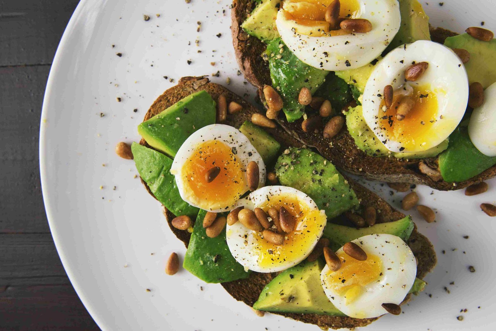 Avocado-Brot mit weich gekochtem Ei und Pinienkernen, reich an Biotin für die Haare