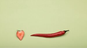 Das Bild zeigt eine halbierte Erdbeere und eine Chili als symbolische Darstellung für Libido.