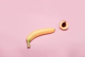 Das Bild zeigt eine Banane und einen halbierten Pfirsich. Es dient als symbolische Darstellung für Diagnose von Libidoverlust.